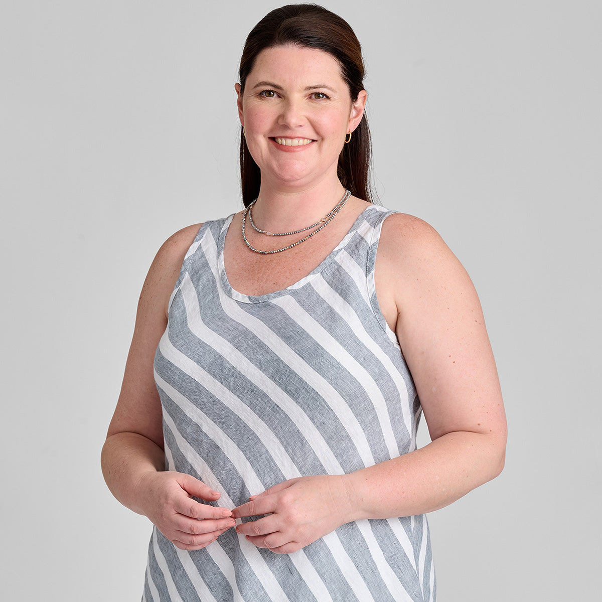 close up shot of woman wearing sleeveless linen shirt in stripe