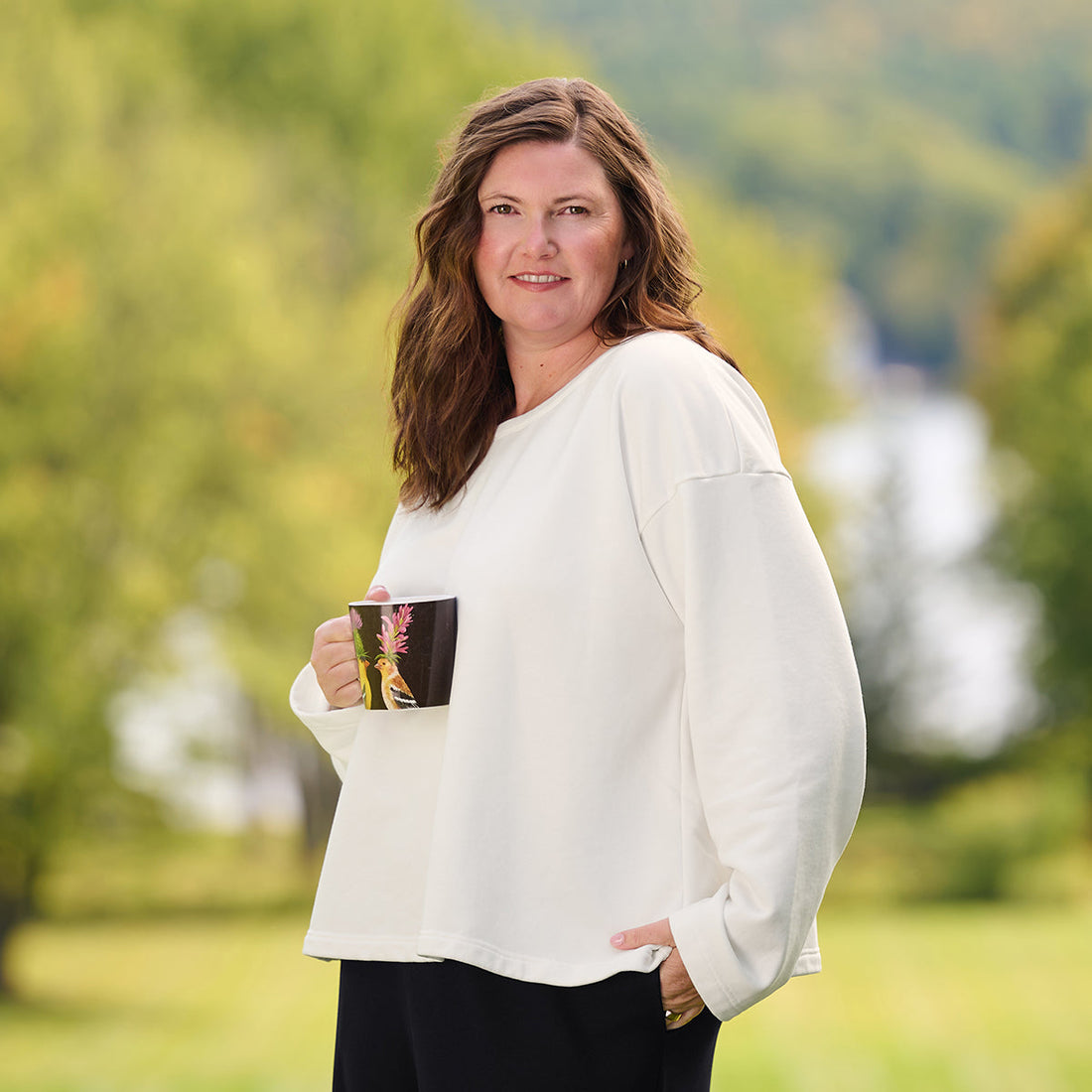 woman outside with a mug wearing a white shirt