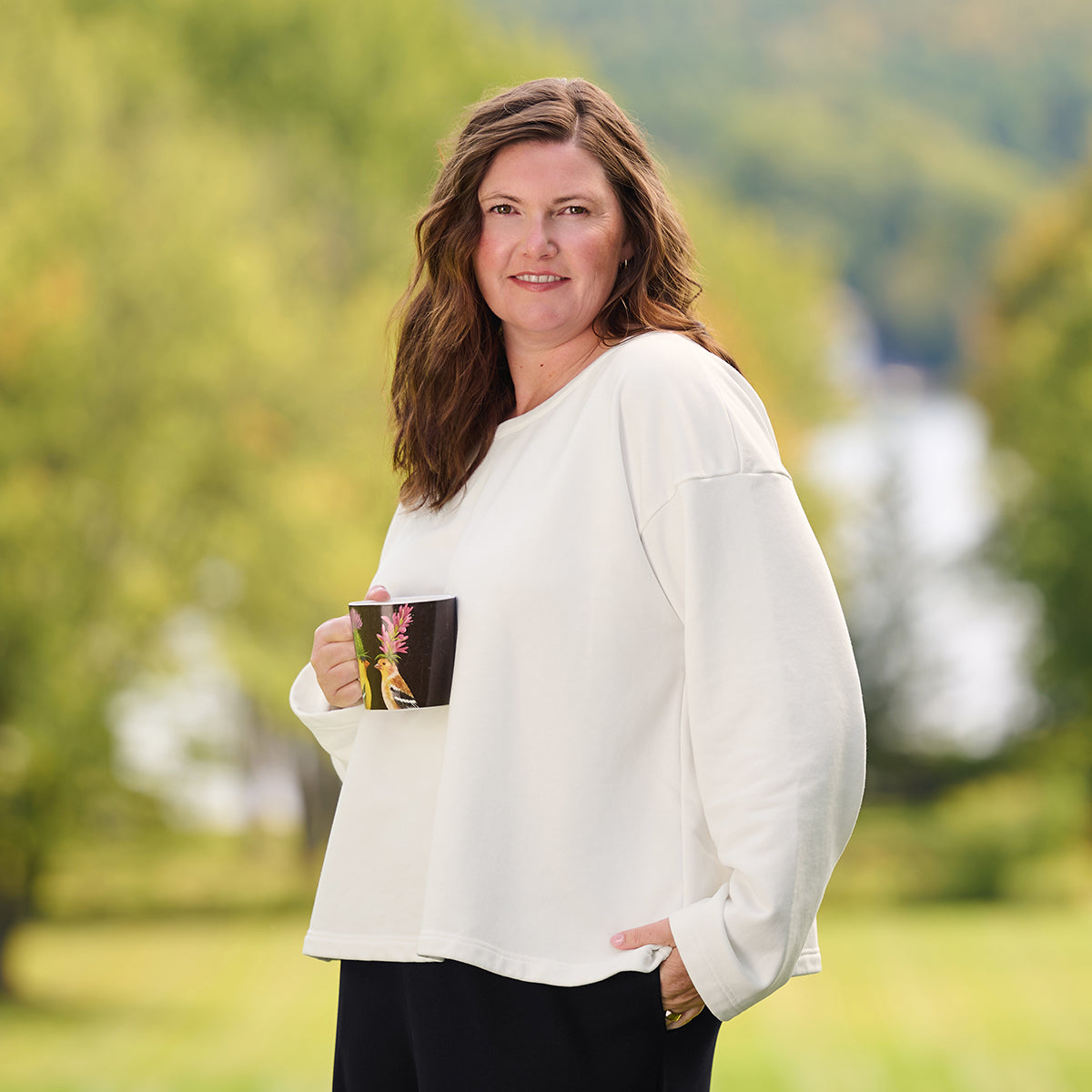 woman outside with a mug wearing a white shirt