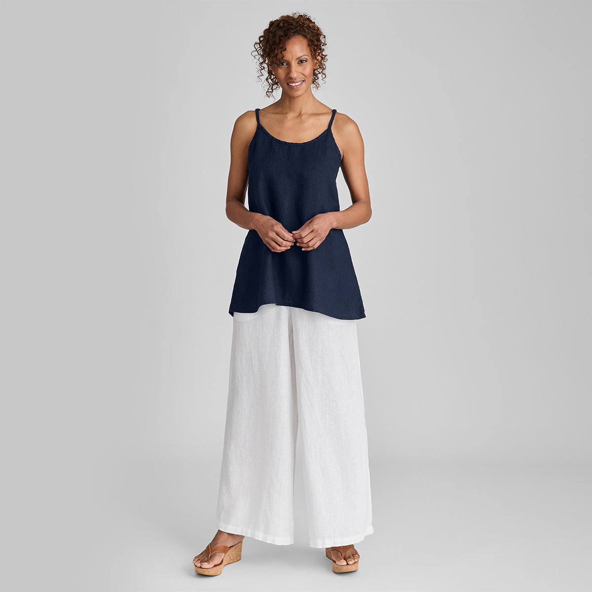 woman wearing blue linen tank top with white linen full length pants