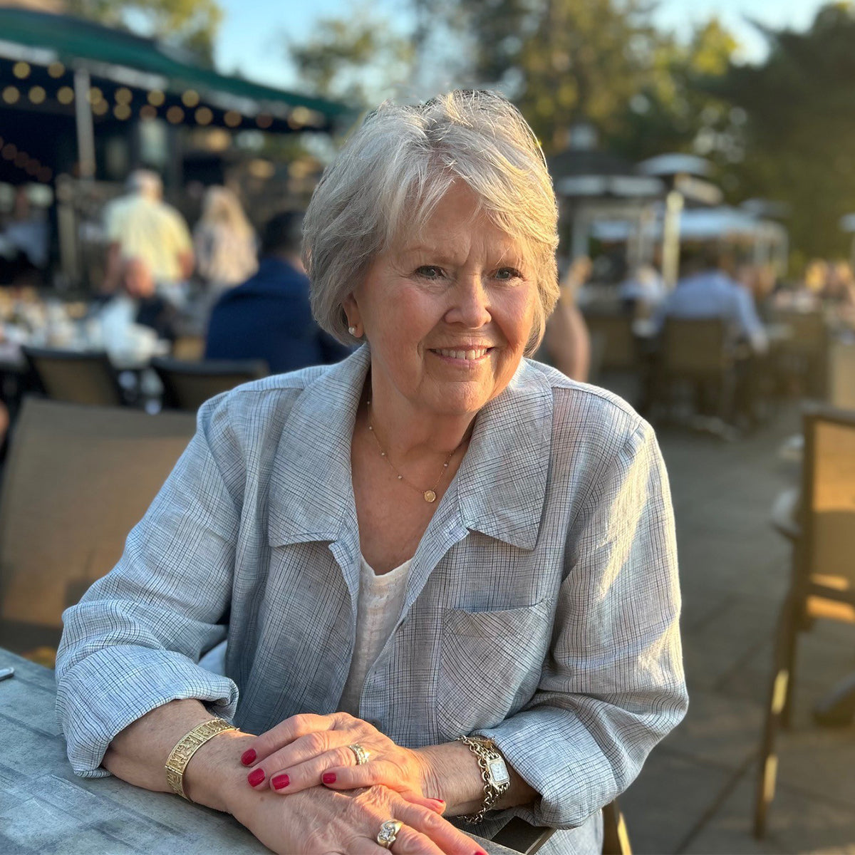 woman outdoors wearing a blue linen button down shirt