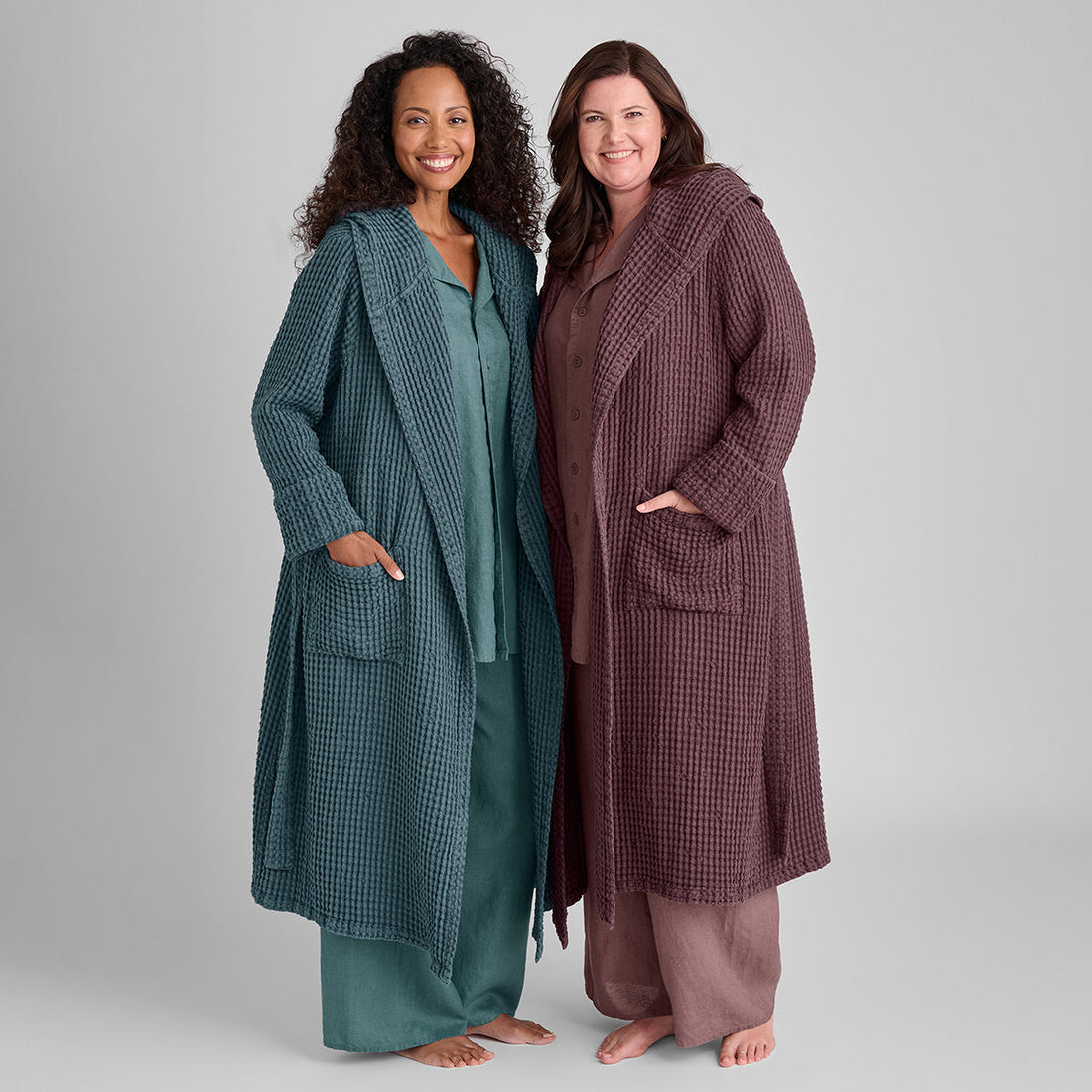 two women standing side by side wearing linen blend bathrobes