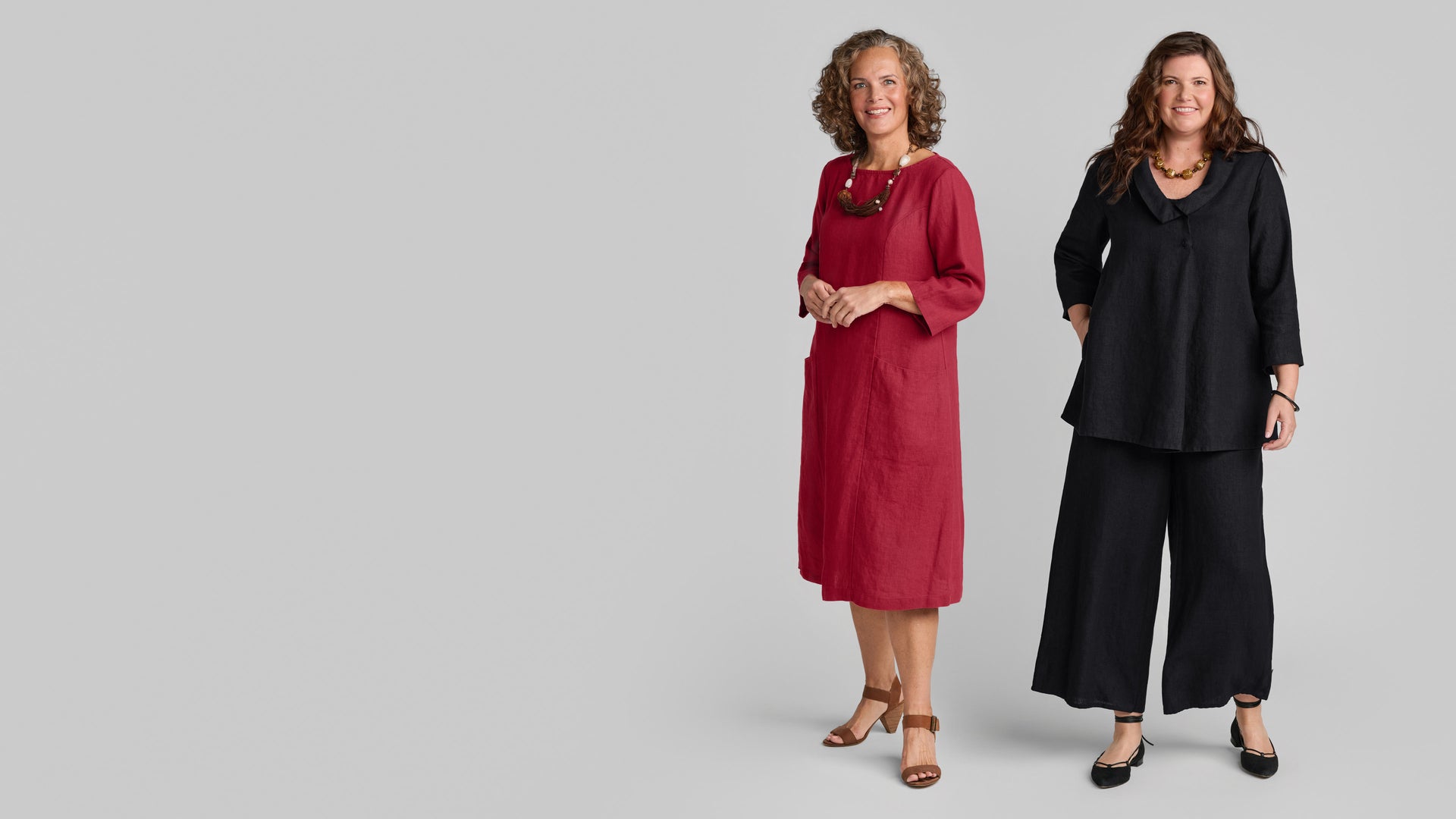 Two women in linen outfits in black and red wearing Flax clothing brand