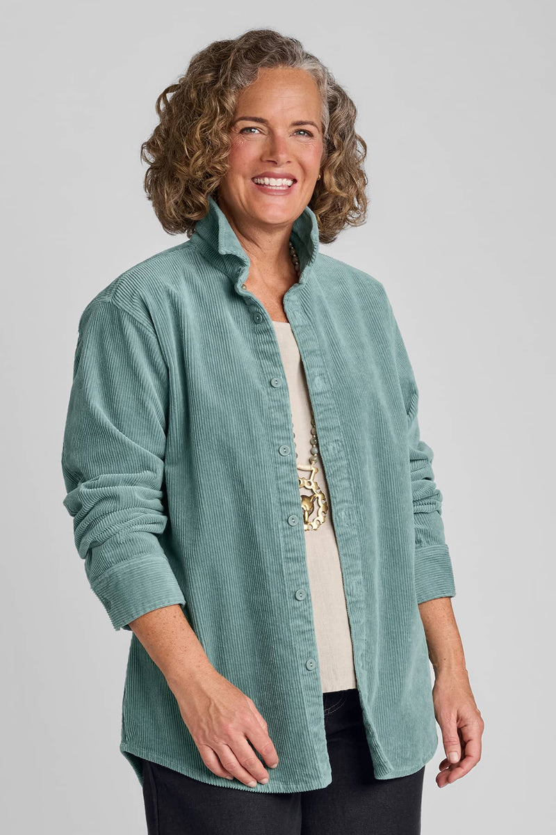 Woman in blue corduroy shirt with rolled up sleeves and denim pants