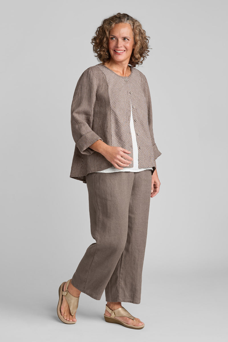 Woman in FLAX clothing brand brown linen button down shirt and brown linen pants