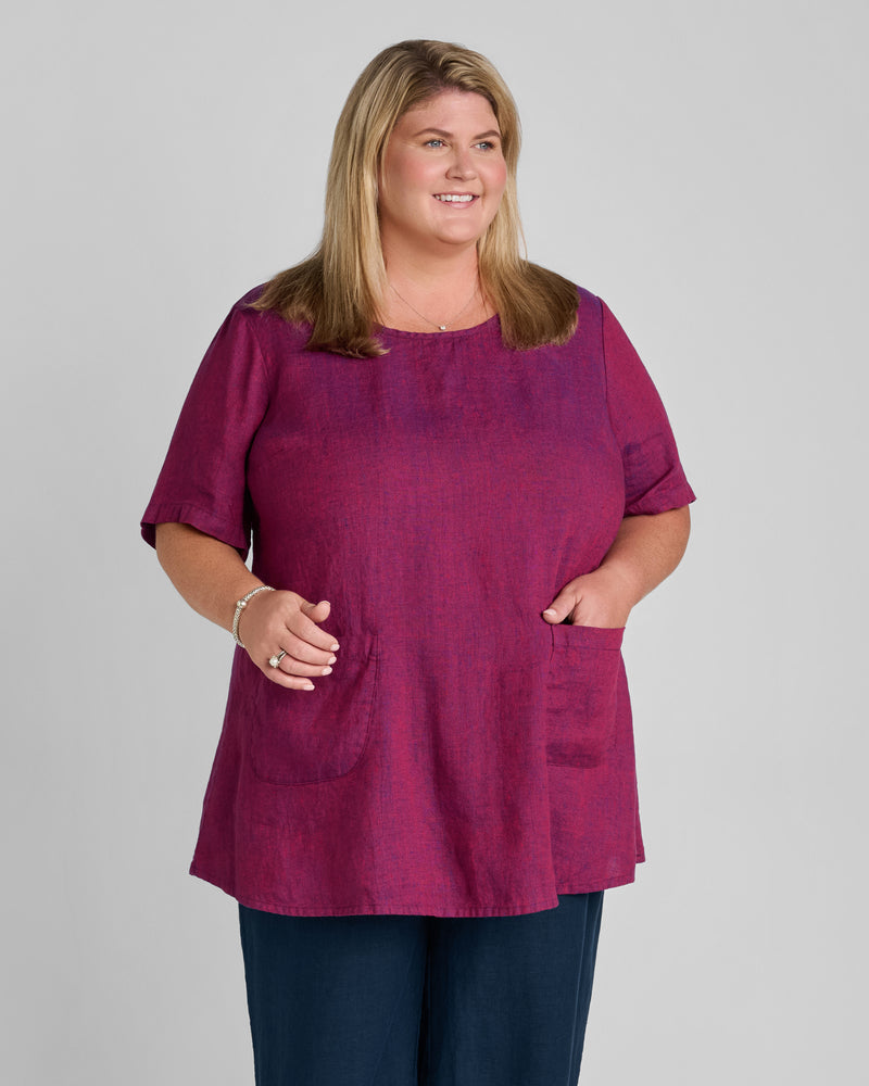 Woman in red linen short sleeve linen tunic with pockets