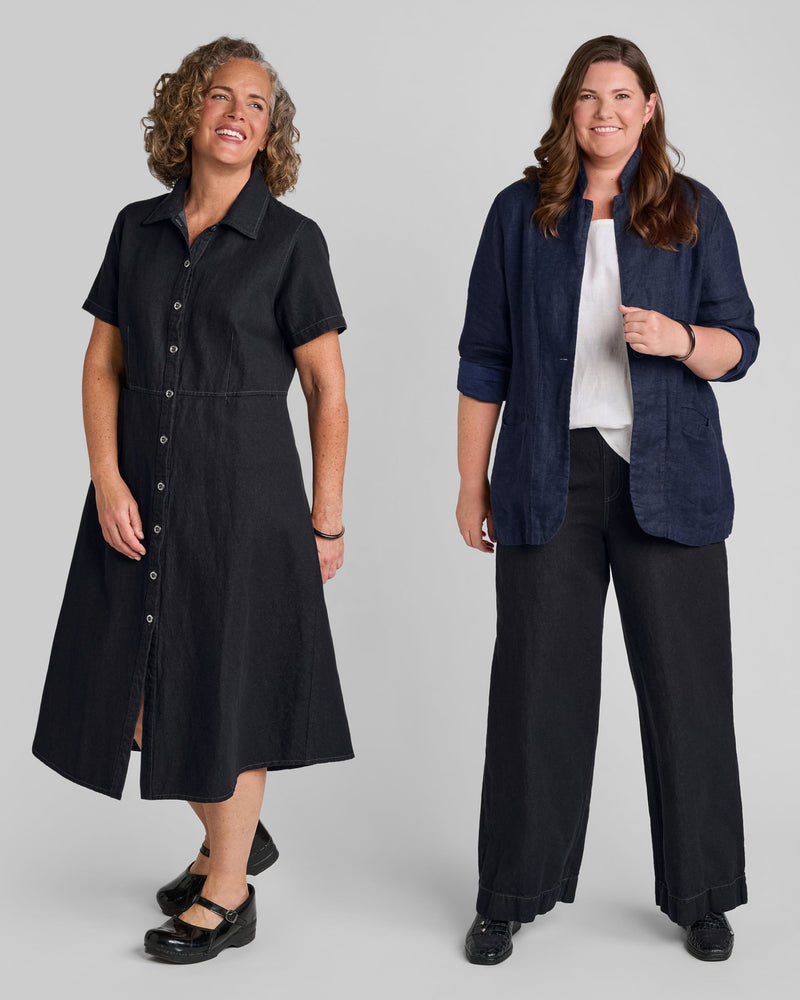 One woman in a black linen/cotton blend dress and another woman in a blue linen/cotton blend blazer with black linen/cotton blend pants.