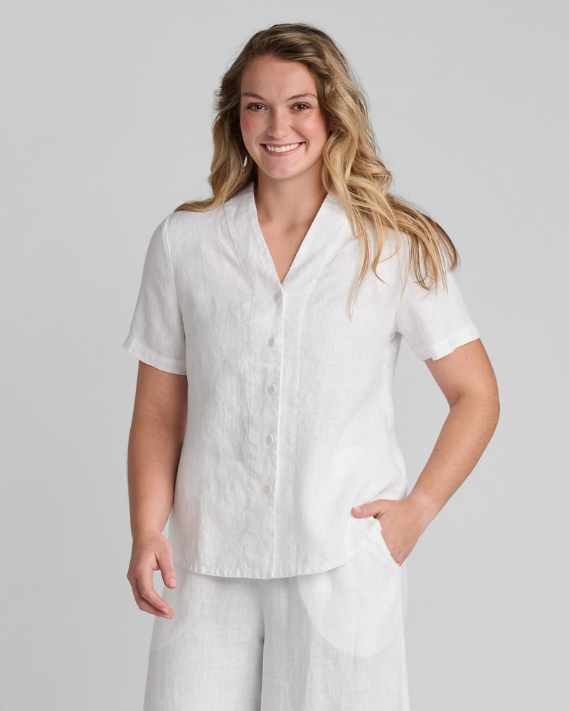 Woman in white linen button down shirt with short sleeves and white linen pants