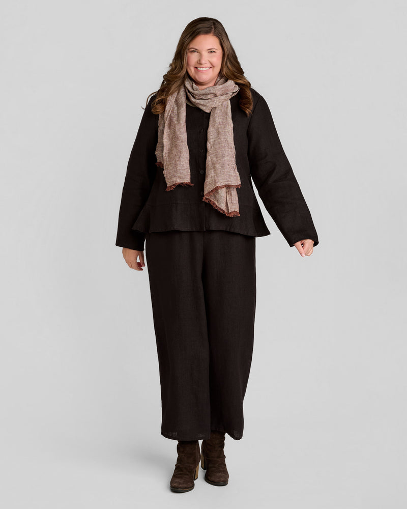 Woman in dark brown long sleeve linen pullover and light brown linen scarf with brown full length linen pants