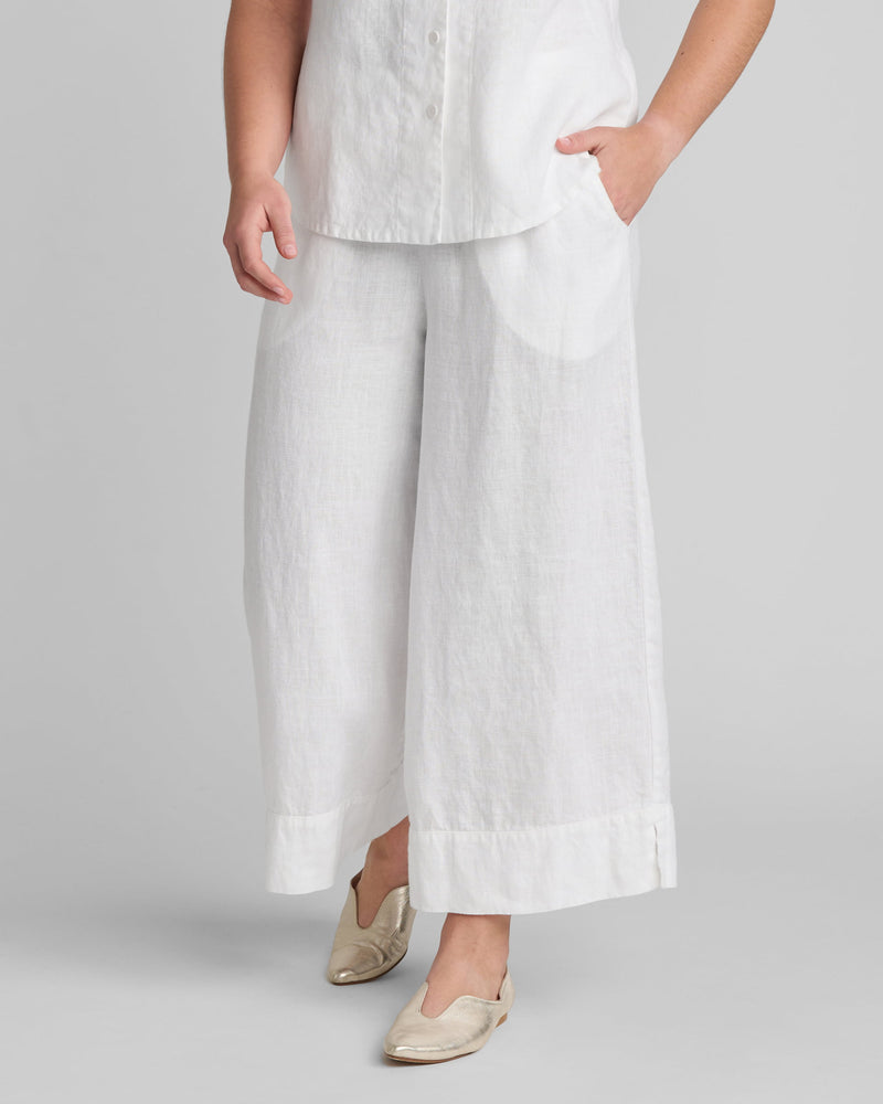 Woman in white linen wide leg pants and white linen shirt