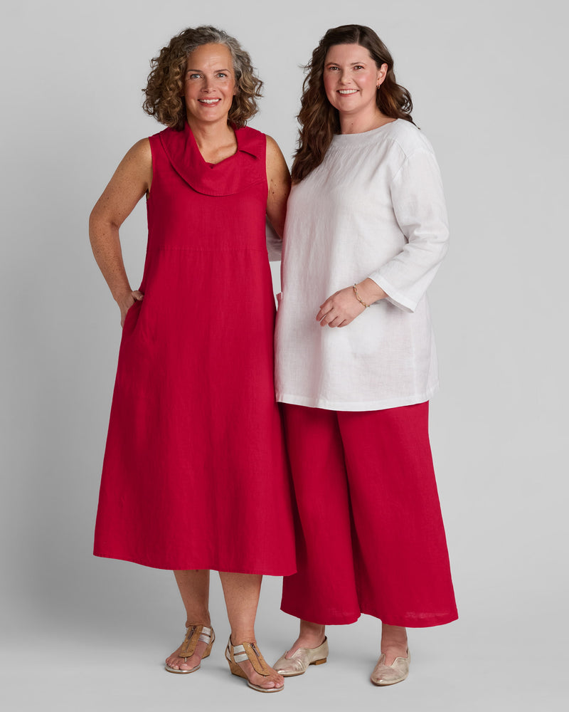 Woman in red linen dress and woman in white linen shirt with red linen wide leg pants