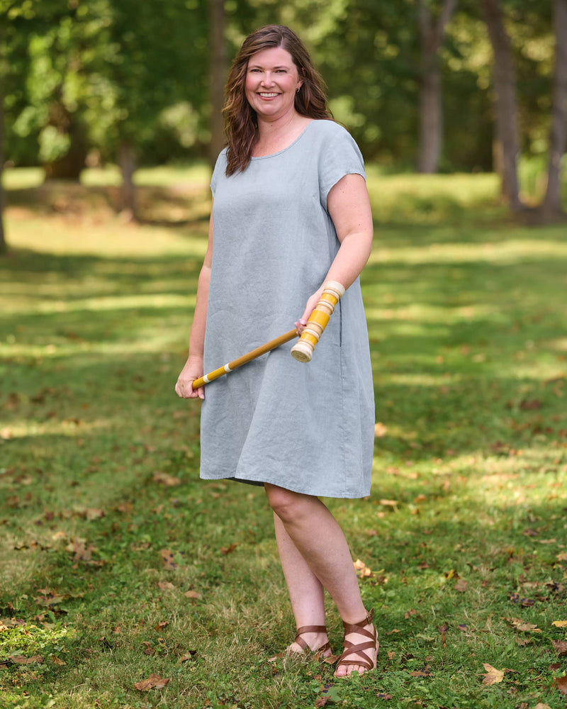 Woman in blue linen dress with pockets and short sleeves