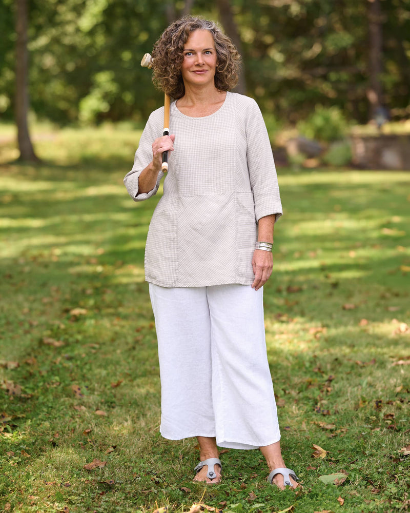 Woman in beige linen tunic and white linen pants