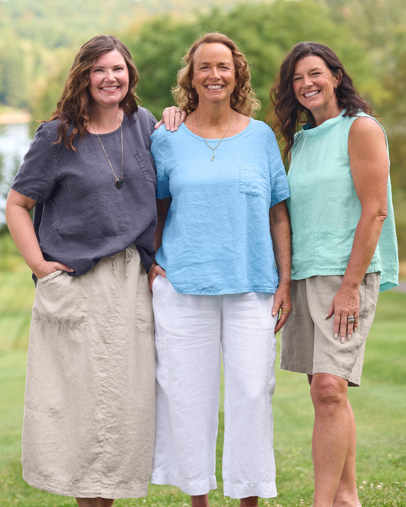 Women in FLAX clothing brand linen shirts, linen pants, and linen shorts