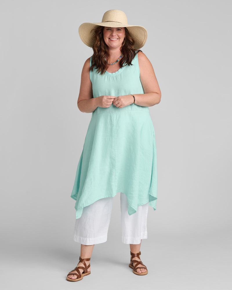 Woman in blue sleeveless linen dress with white linen pants
