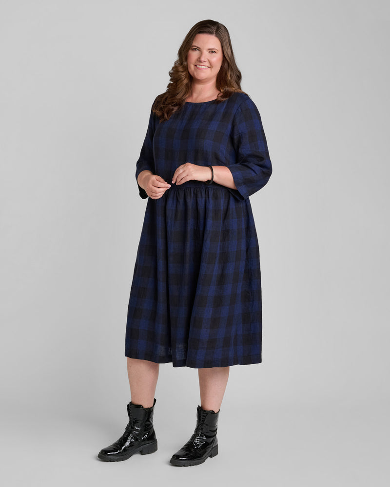 Woman in black and blue plaid line dress