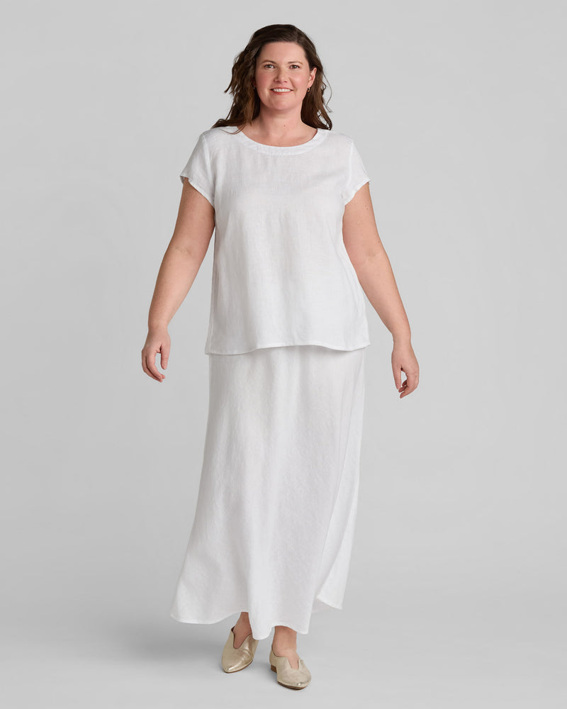 Woman in white linen tee shirt and white linen maxi skirt