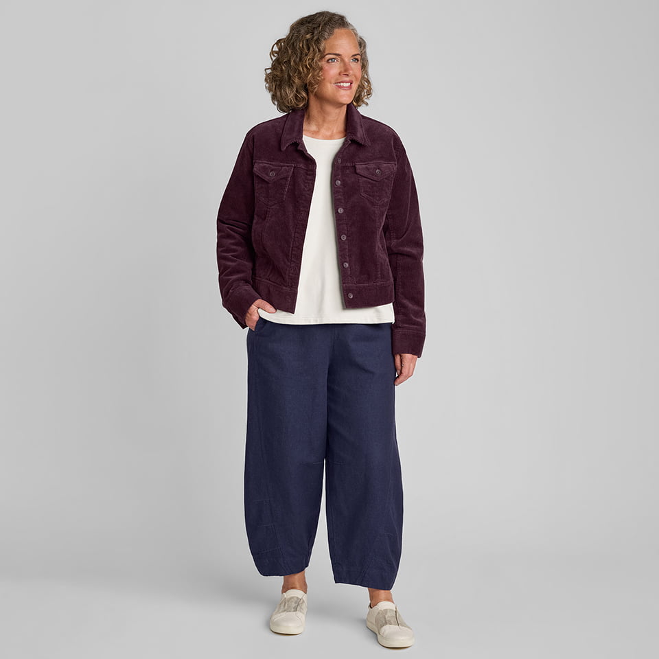 Woman in red corduroy jacket with white under shirt and blue linen/cotton blend pants