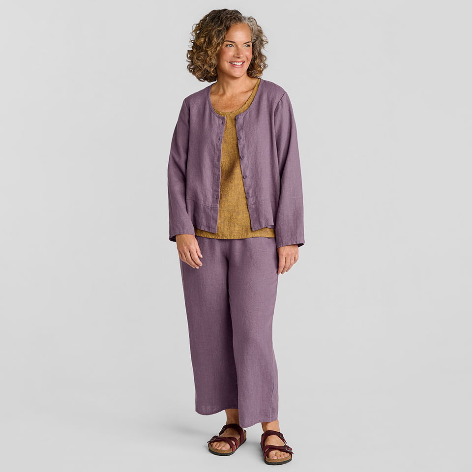 Woman in purple linen jacket with a brown linen undershirt and purple linen pants