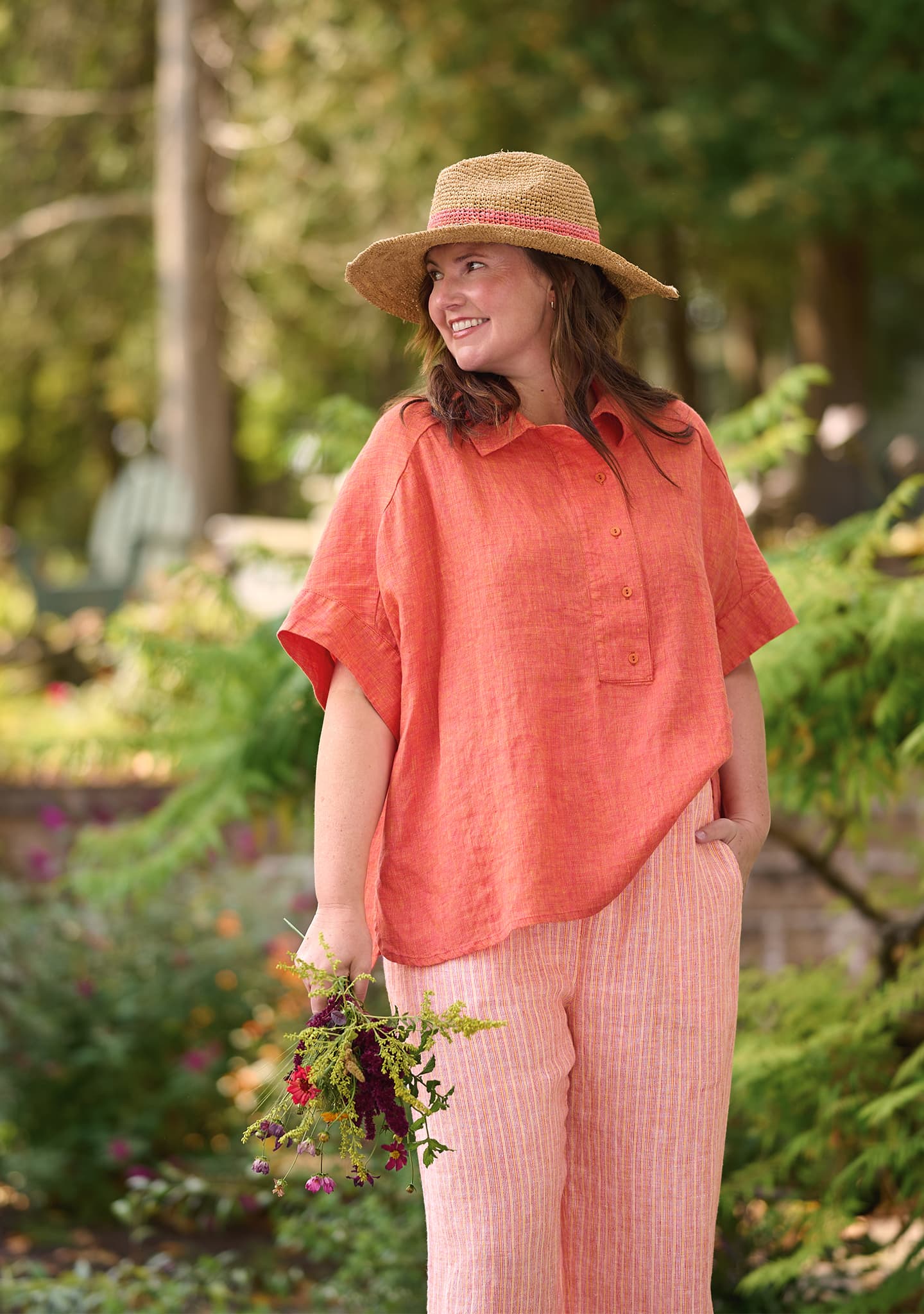 woman outdoors in linen pullover in orange and linen pants in orange stripe