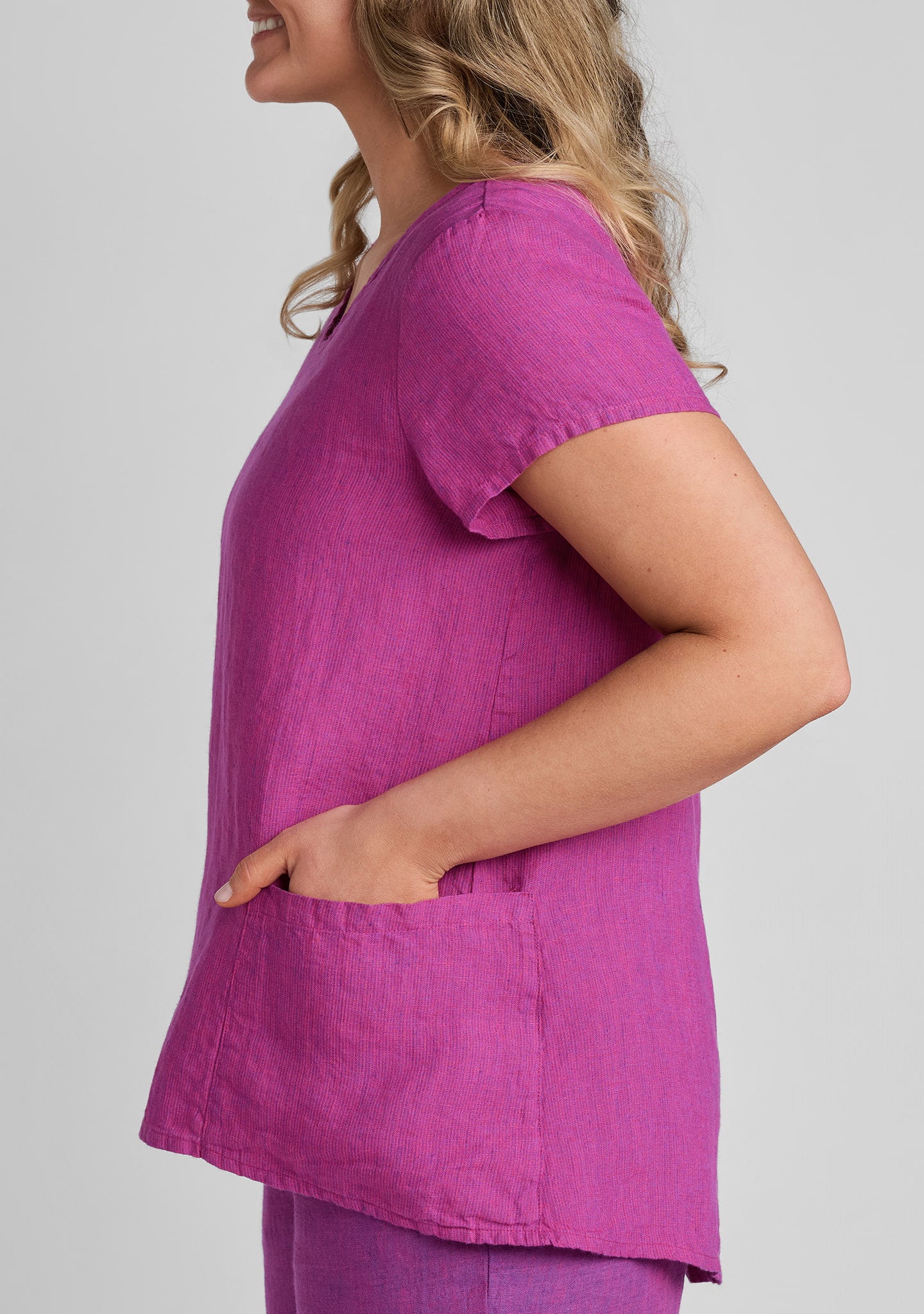 side view of pocket detail and hem on women's linen shirt in purple