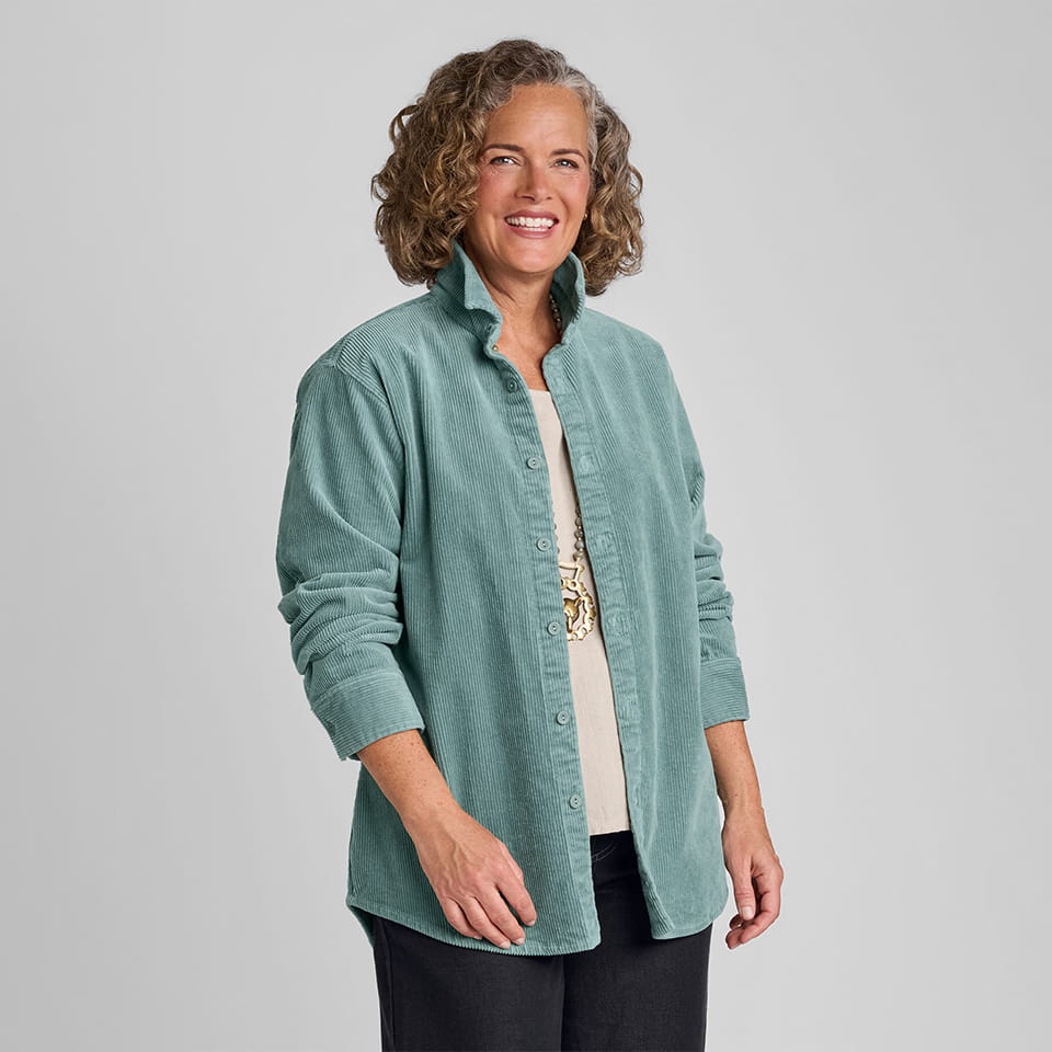 Woman in blue corduroy shirt with rolled up sleeves and black linen/cotton blend pants