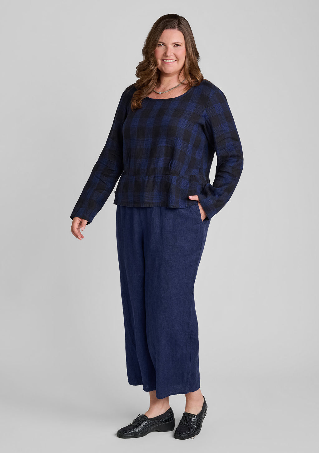 woman modeling a navy blue plaid long-sleeve top and matching navy wide-leg pants