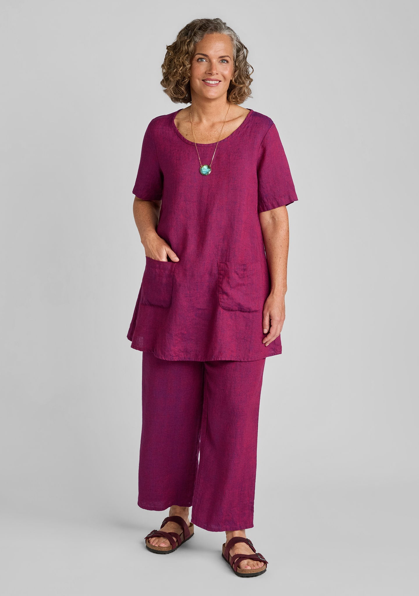 woman wearing matching linen outfit in red featuring flood pants