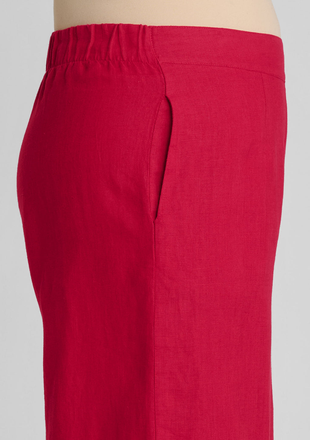 side view of waistband with elastic in back and a flat front and pocket on women's linen pants in red