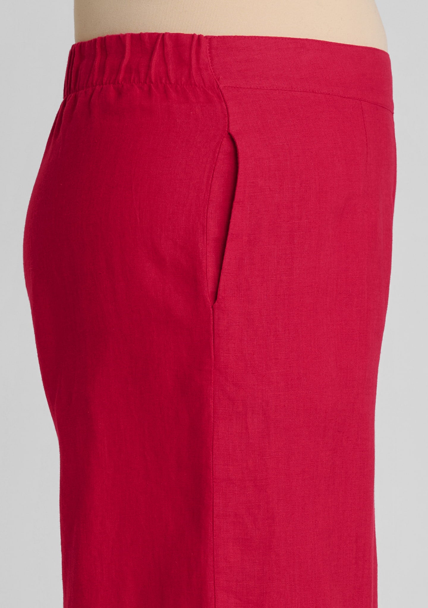 side view of waistband with elastic in back and a flat front and pocket on women's linen pants in red