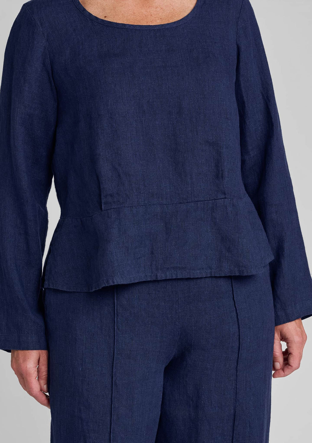 close up detail of the peplum on a blue linen top