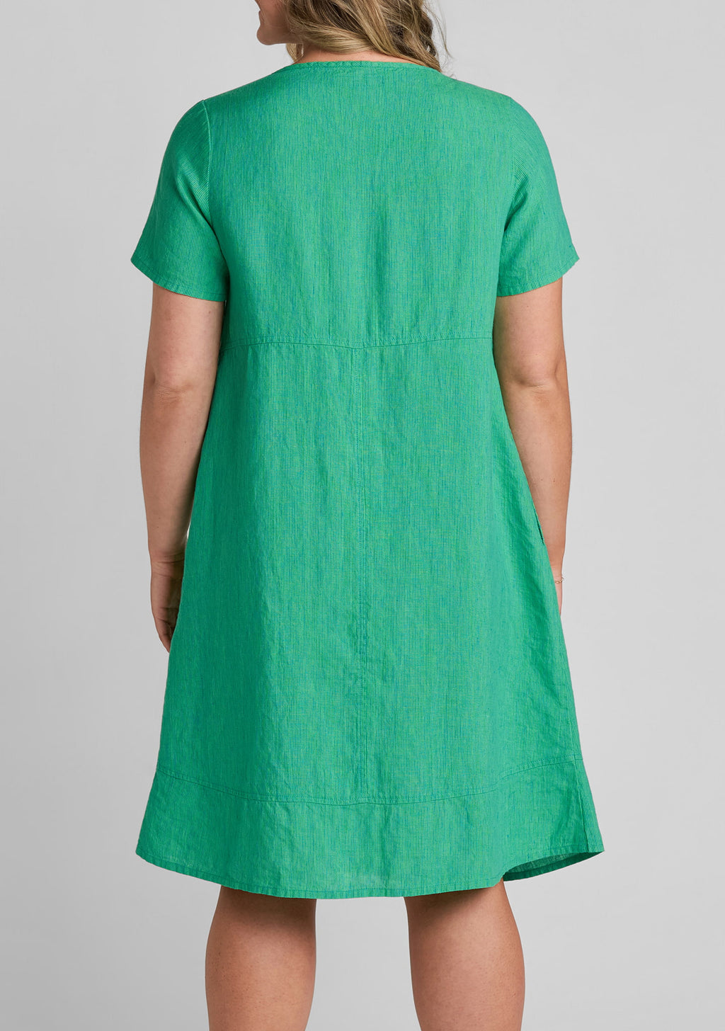 close up view of fabric on the back of women's linen dress in green