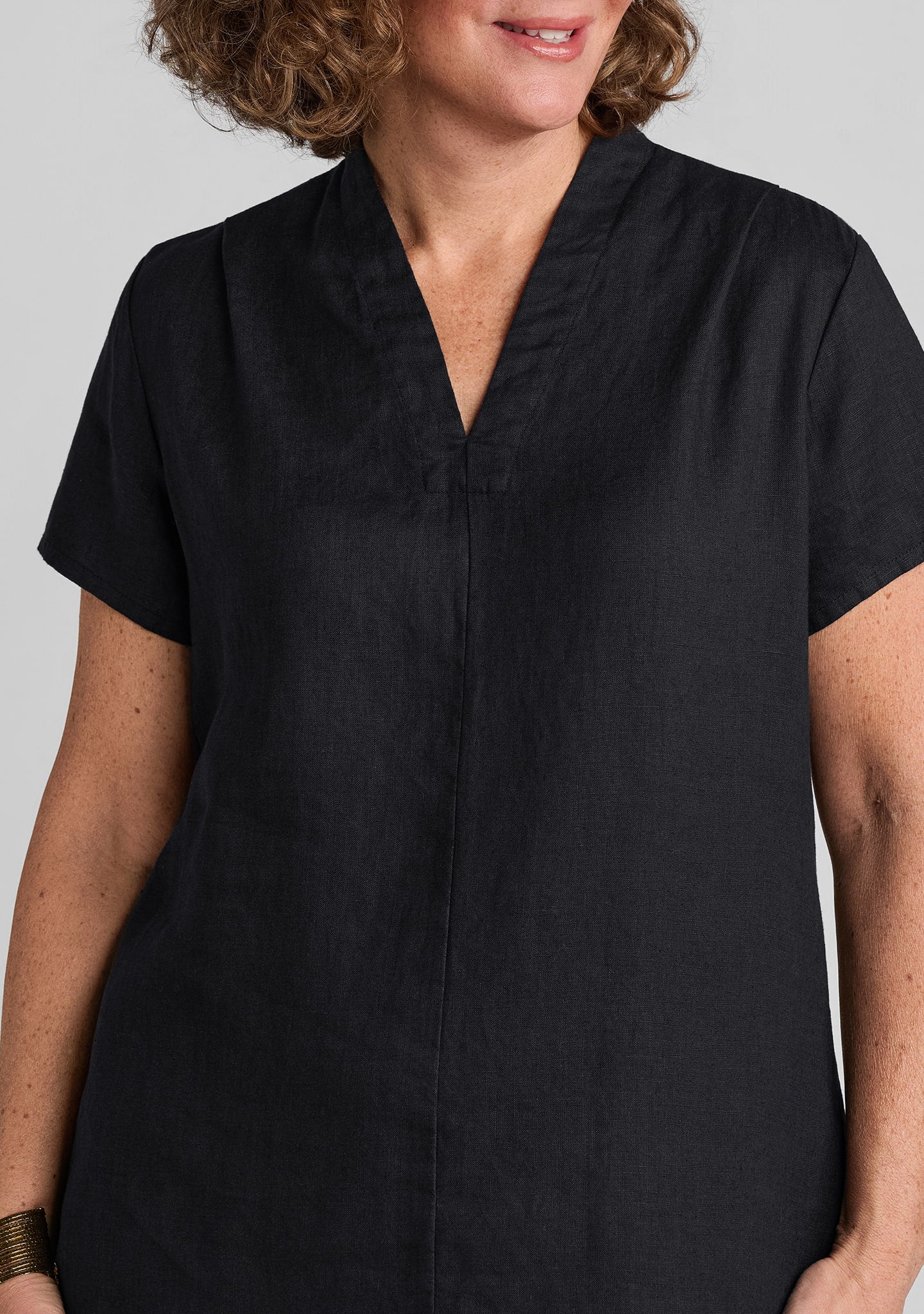 close up view of neckline and seaming details on women's black linen dress