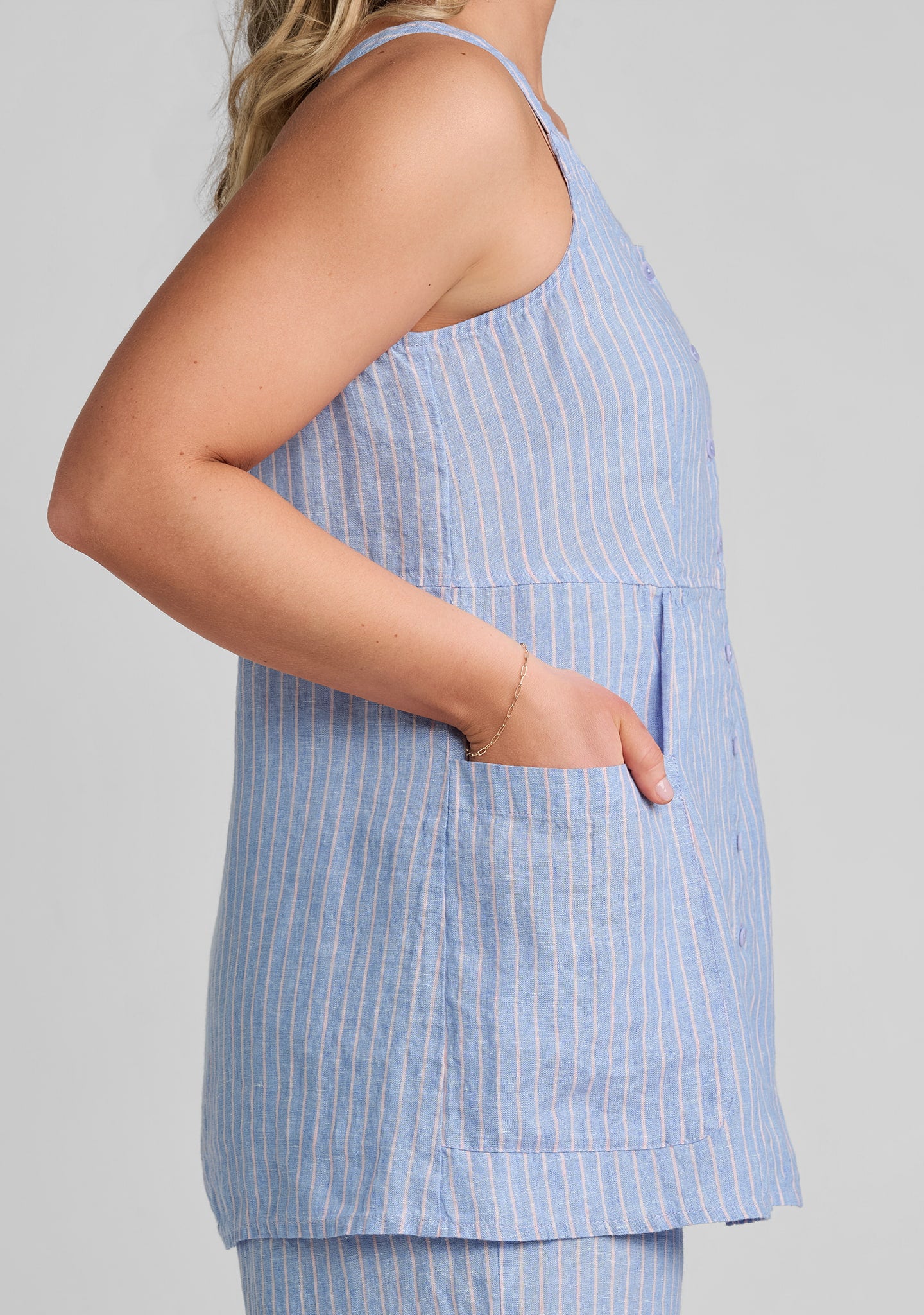 side view of hand in pocket on blue linen shirt