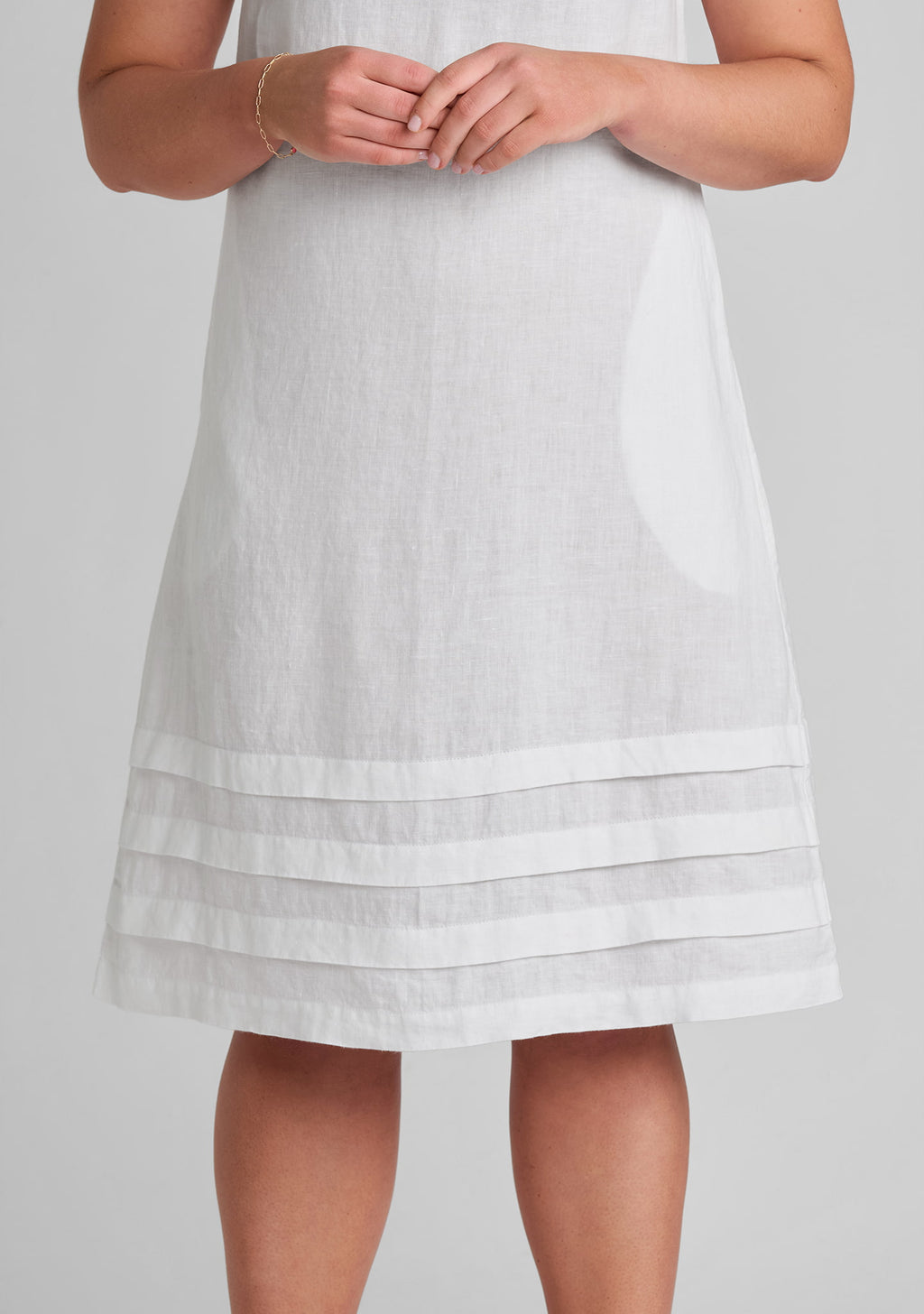 close up of tuck details on women's linen dress in white